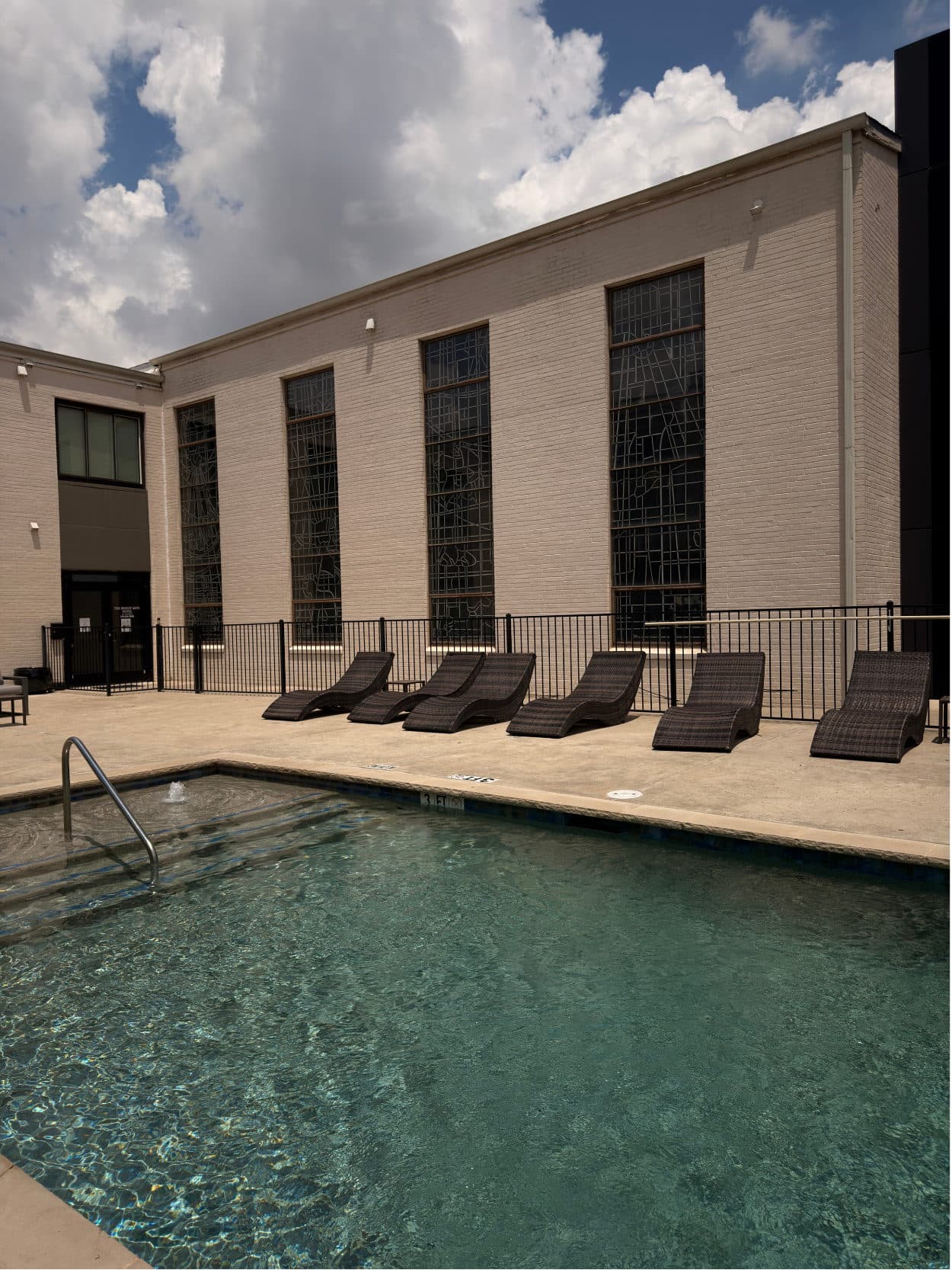 Outdoor pool lined with loungers