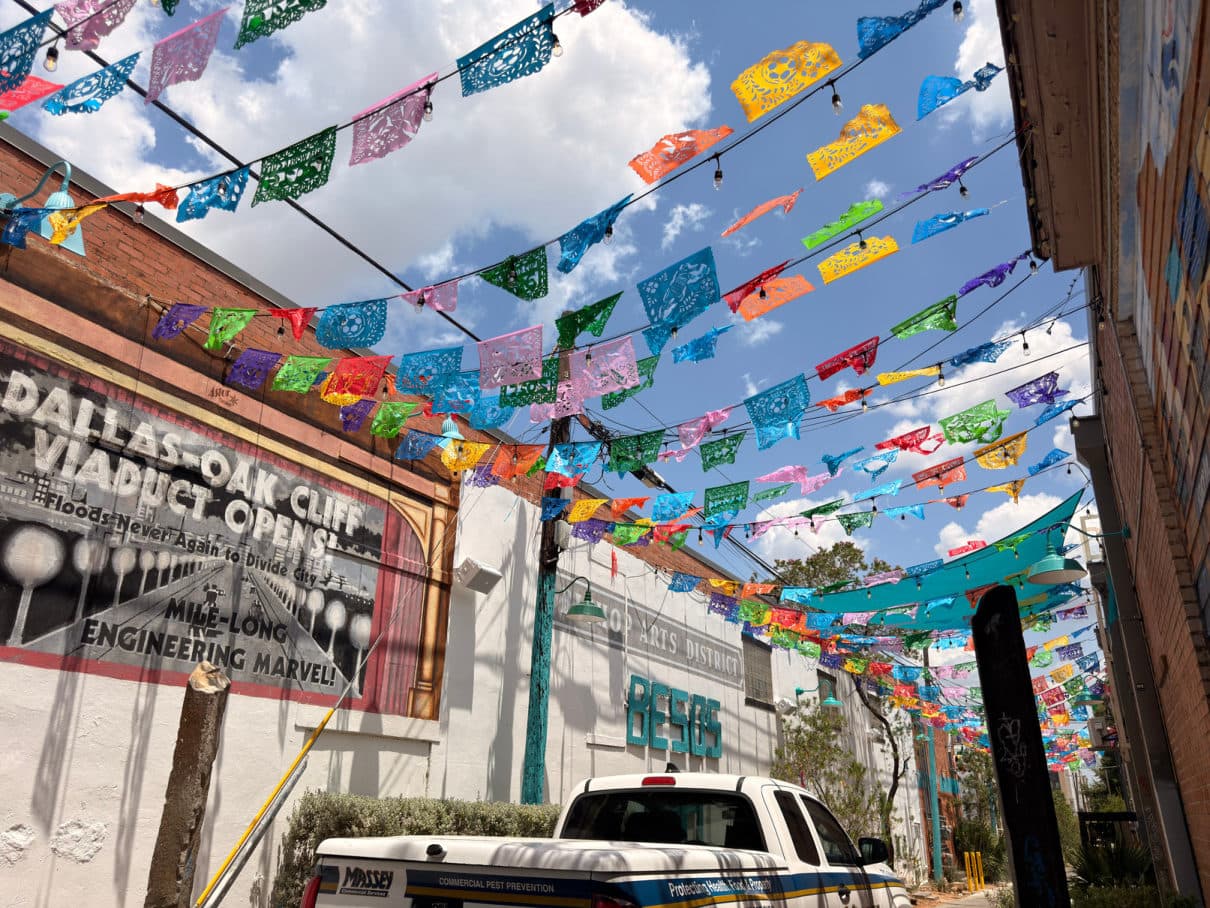 Papel picado strung above a Bishop Arts street