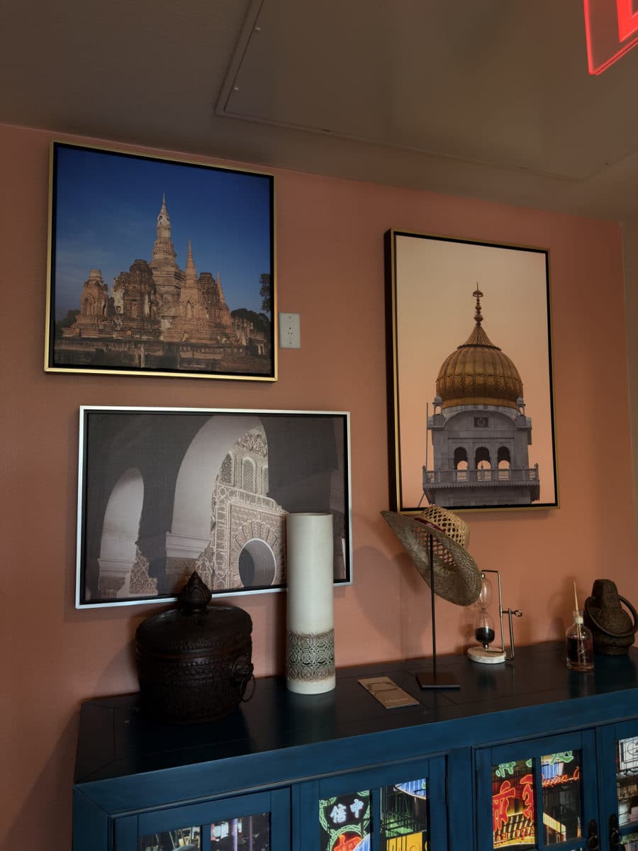 Framed architectural prints above a teal cabinet
