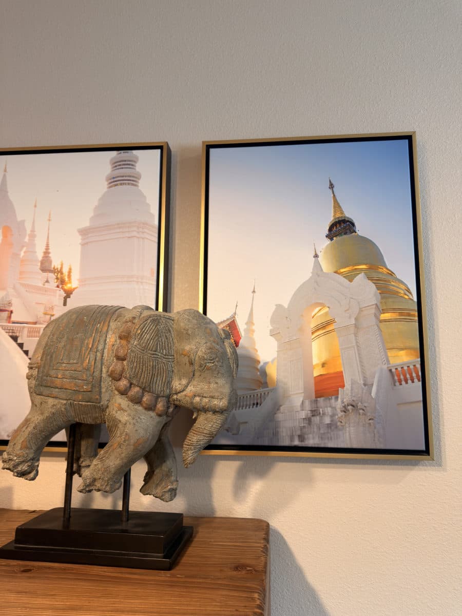 Carved elephant beside framed temple prints