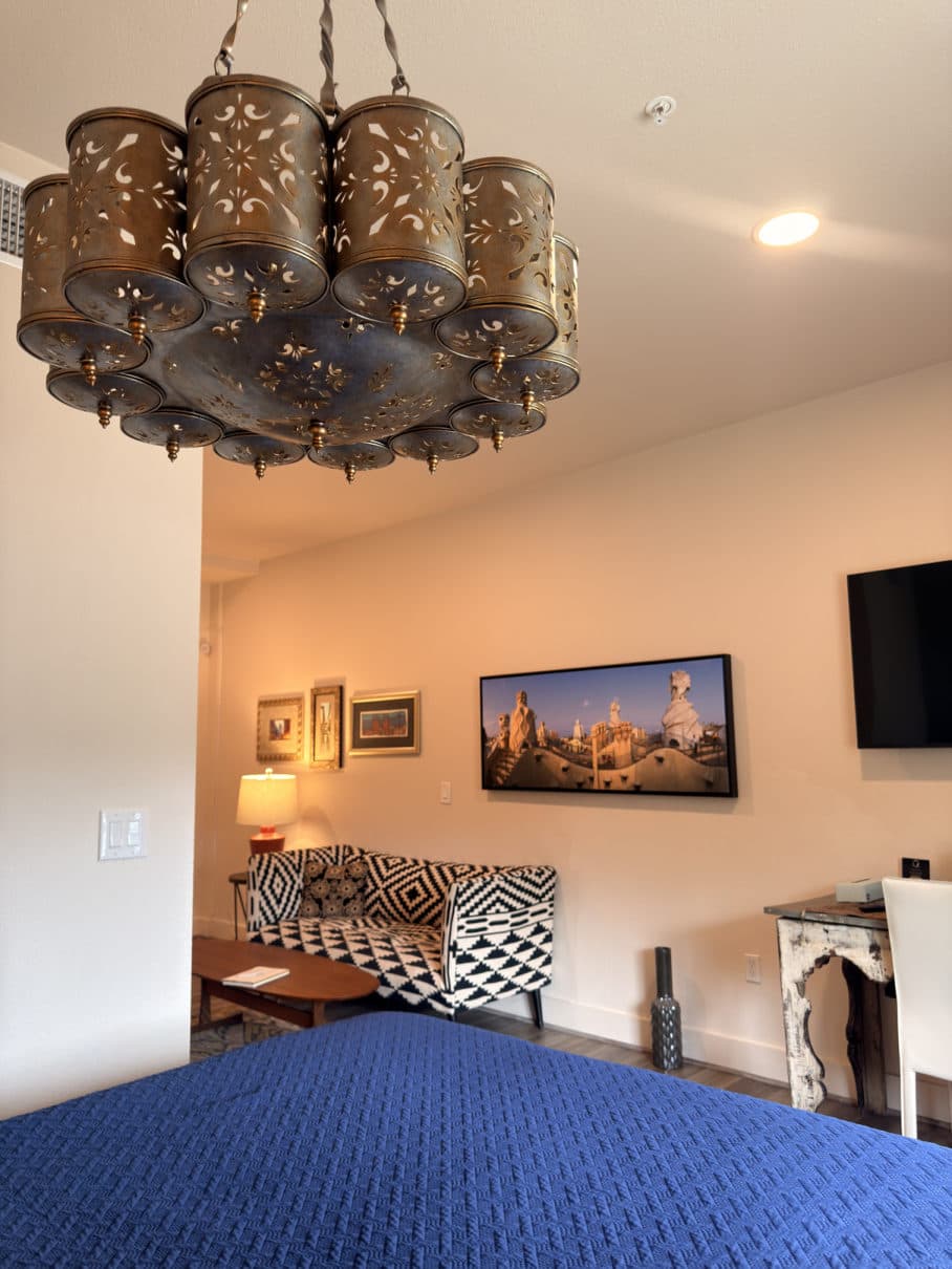 Indigo bed beneath a beaded chandelier
